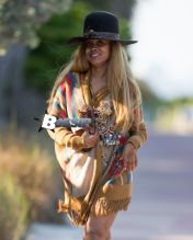 Erykah Badu takes a stroll in a unique looking outfit during a vacation in Miami. The 42-year-old music legend wore an African themed ensemble with a large African tribal necklace over her knitted cardigan and Henna tattoos all over her body. Her large hat had a rattle snake skin around it.