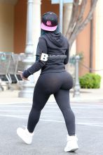 Blac Chyna flashes the peace sign on her way inside a Ralph's grocery store in Calabasas. The former King of Diamonds dancer showed off her extreme assets in a pair of black leggings, black Adidas hooded sweatshirt and a pink and black Last Kings ball cap.