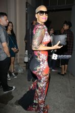 Amber Rose arriving at Lana Del Rey concert with beautiful smile. Amber looks amazing in a asian inspired red and black form fitting dress carrying a black clutch.
