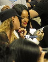 Rihanna watches her ex boyfriend Chris Brown as he plays a charity basketball while she sits courtside with Cara Delevingne. The girls were talking as Chris played ball and Chris did not look over at her but Rihanna looked at him many times as he went up and down the court. Later she was seen smiling as she posed with many children and even hugged as they came up to greet her