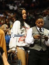 Rihanna watches her ex boyfriend Chris Brown as he plays a charity basketball while she sits courtside with Cara Delevingne. The girls were talking as Chris played ball and Chris did not look over at her but Rihanna looked at him many times as he went up and down the court. Later she was seen smiling as she posed with many children and even hugged as they came up to greet her