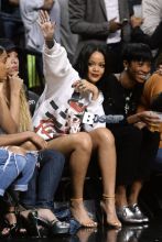 Rihanna watches her ex boyfriend Chris Brown as he plays a charity basketball while she sits courtside with Cara Delevingne. The girls were talking as Chris played ball and Chris did not look over at her but Rihanna looked at him many times as he went up and down the court. Later she was seen smiling as she posed with many children and even hugged as they came up to greet her