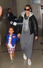 Los Angeles, CA - Alicia Keys smiles wide as she makes her way through LAX Airport with her son Egypt following a late flight into Los Angeles. Alicia, who is pregnant with her second child, is currently a mentor to Pharrell Williams’ team on ‘The Voice’. The braided R&B singer wore a black leather jacket over a splatter painted grey dress, white sneakers and a pair of sunglasses.