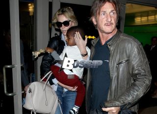 Charlize Theron and Sean Penn arrive at LAX airport with Charlize's son Jackson Theron, where Charlize covers her son face as they head to the car.