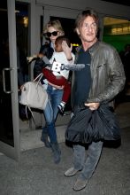 Charlize Theron and Sean Penn arrive at LAX airport with Charlize's son Jackson Theron, where Charlize covers her son face as they head to the car.