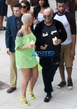 January 18, 2015: Amber Rose removes her neon green mesh cover-up to reveal a sheer yellow bikini top by the pool in Miami.