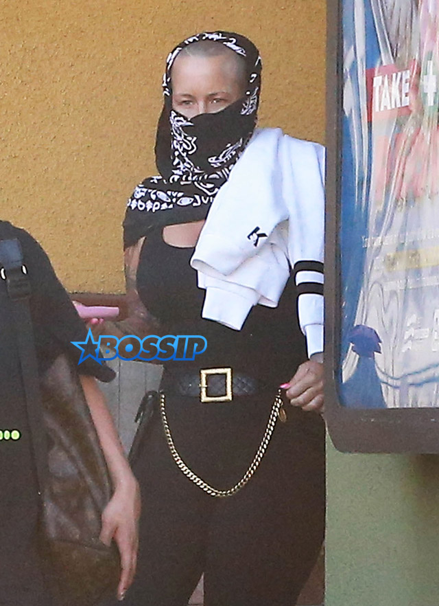 Model Amber Rose hides her face with a black scarf while leaving a nail salon in Studio City, California