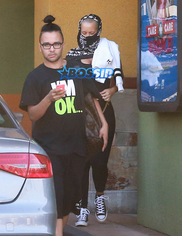 Model Amber Rose hides her face with a black scarf while leaving a nail salon in Studio City, California