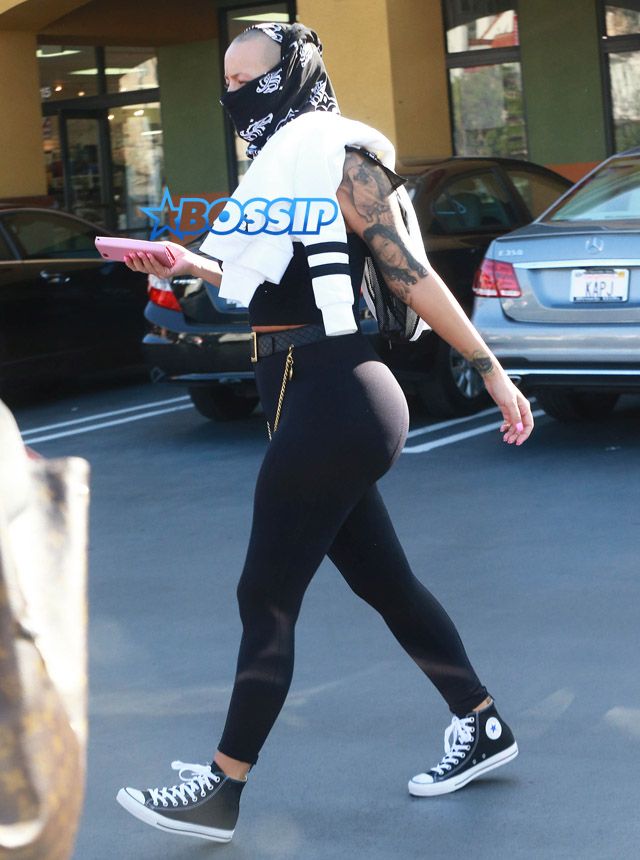 Model Amber Rose hides her face with a black scarf while leaving a nail salon in Studio City, California