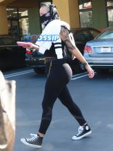 Model Amber Rose hides her face with a black scarf while leaving a nail salon in Studio City, California