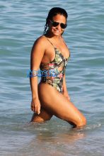 AKM-GSI Christina MIlian wears floral pineapple black thong one-piece and baseball cap for Miami Beach day with daughter Violet