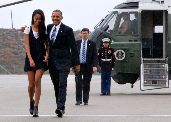 President Barack Obama walks with daughter Malia Obama through a light rain to from Marine One to board Air Force One prior to leaving Los Angeles, Friday, April 8, 2016, en route to San Francisco where he is expected to attend Democratic fundraisers. (AP Photo/Jacquelyn Martin)
