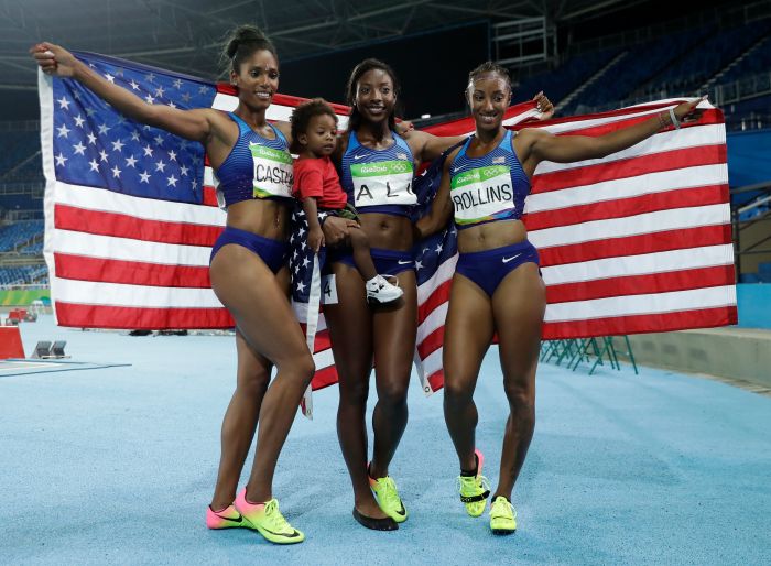 Gold medal winner Brianna Rollins, right, silver medal winner, Nia Ali, center, and bronze medal winner Kristi Castlin, left, all from the United States, celebrate with their country's flag, during the athletics competitions of the 2016 Summer Olympics at the Olympic stadium in Rio de Janeiro, Brazil, Wednesday, Aug. 17, 2016. (AP Photo/Matt Slocum)