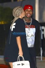 AKM-GSI Kylie Jenner boyfriend Tyga kiss Kanye West's Saint Pablo LA Tour tThe Forum. T Jordyn Woods security. dressed oversized black shirt, cherry red shoes cornrows, braids.