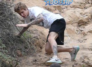 Justin Bieber run rainy windy day falls hike generosity water WENN