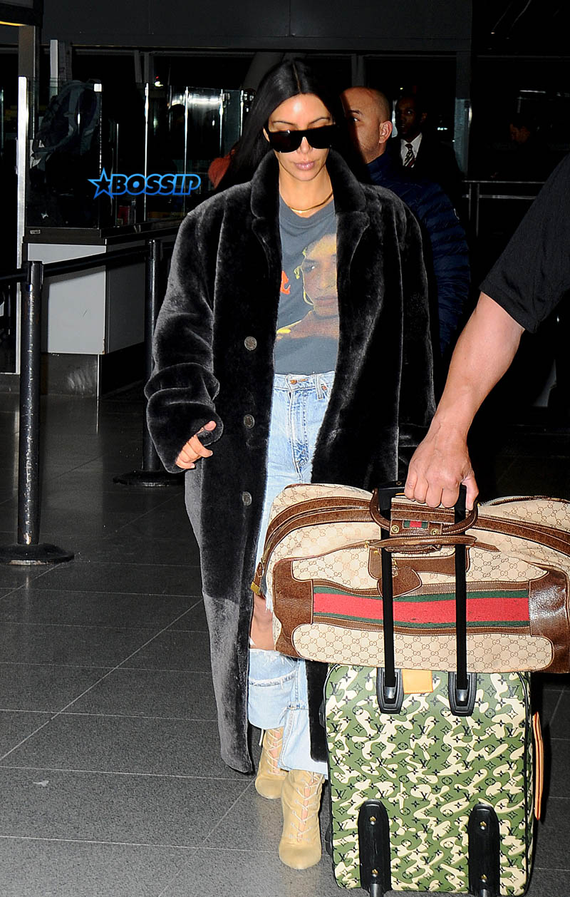 Kim Kardashian arrives wearing a Sinead O'connor shirt and fur coat to New York City, New York, after leaving Dubai. SplashNews