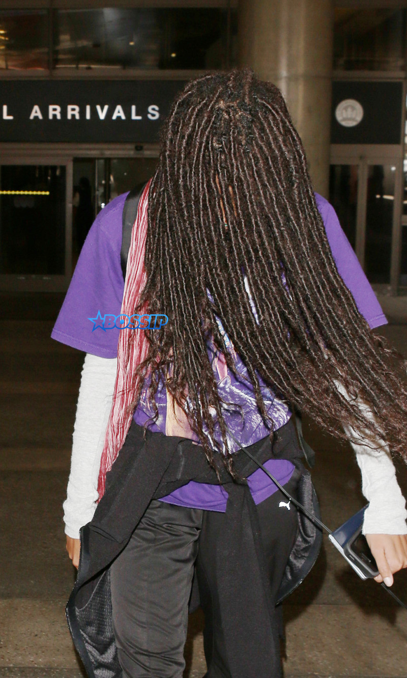 Willow Smith does her best impression of cousin It from the Addams Family as she uses her hair to hide her face as she arrives at LAX Airport in Los Angeles, Ca