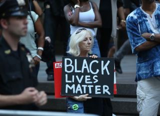 NEW YORK, USA - AUGUST 23 : A woman holds a banner reading "Black Lives Matter" during a rally against the National Football League (NFL), supporting Colin Kaepernick in Manhattan borough of New York, United States on August 23, 2017.