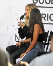 Khloe Kardashian employs best friend Malika as a "bump blocker" as she attends a "Good American" event at Nordstroms in Century City, CA. A tiny bump is visible from the side.