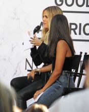 Khloe Kardashian employs best friend Malika as a "bump blocker" as she attends a "Good American" event at Nordstroms in Century City, CA. A tiny bump is visible from the side.