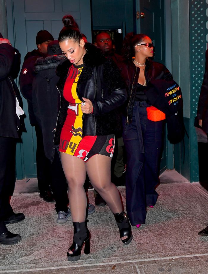Rihanna leaving Avenue Nightclub early Saturday futuristic pair of Dior Sunglasses which she designed joined by OITNB star, Dascha Polanco, in a tight red and yellow dress. Rihanna covered her "engagement ring" w/ her Balenciaga hoodie as she walked out surround by security
