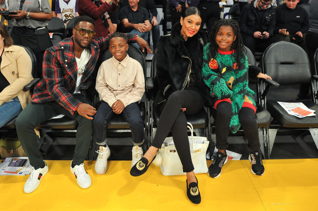 LOS ANGELES, CA - DECEMBER 25: (L-R) Comedian Kevin Hart, son Hendrix Hart, wife Eniko Parrish and daughter Heaven Hart attend a basketball game between the Los Angeles Lakers and the Minnesota Timberwolves at Staples Center on December 25, 2017 in Los Angeles, California.