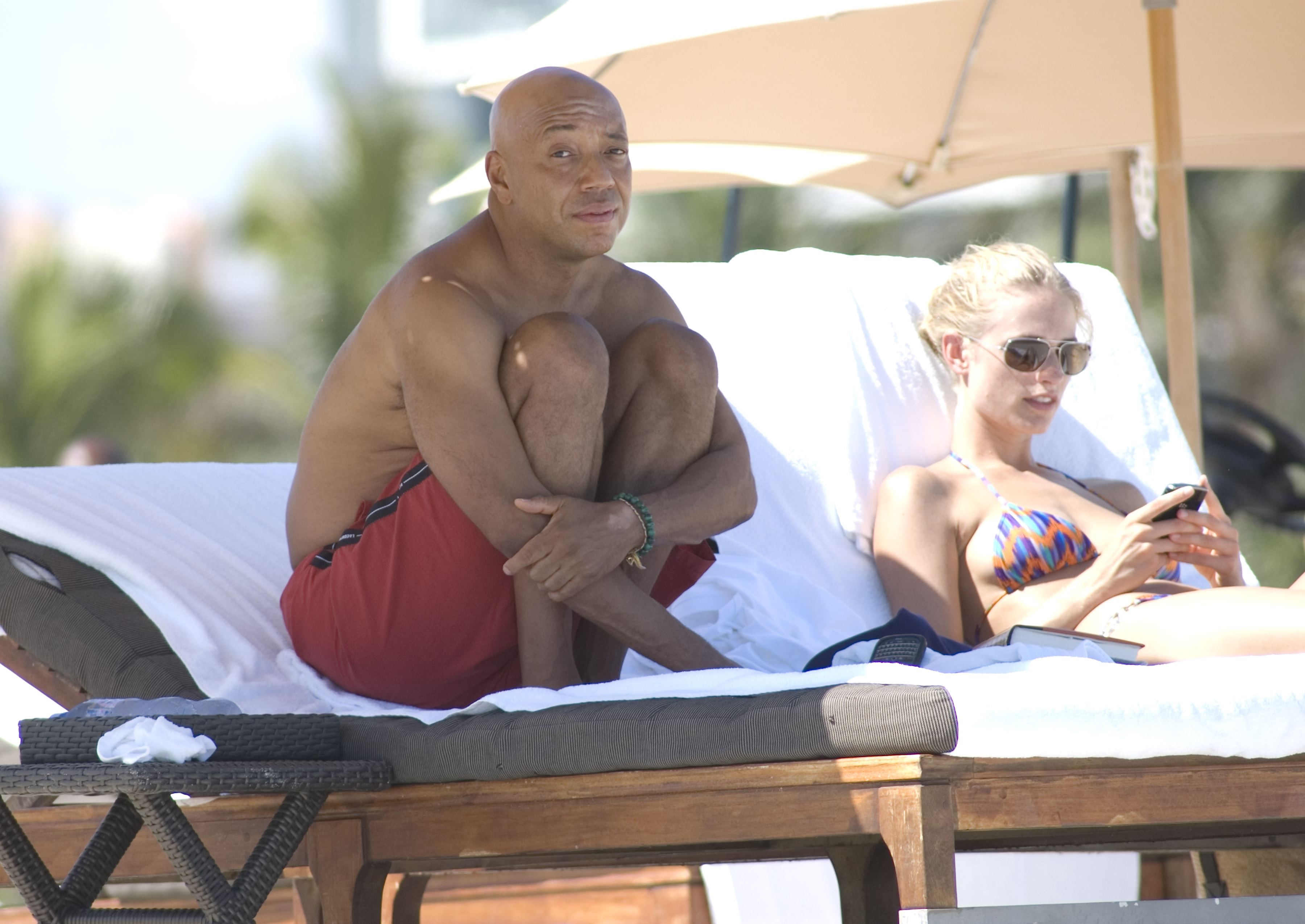 Russell Simmons does yoga and goes for a swim with his girlfriend Julie Henderson. He even takes the time to help out a homeless person with a little cash assistance in Miami Beach, Florida.