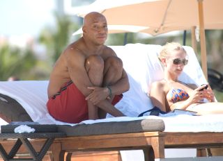 Russell Simmons does yoga and goes for a swim with his girlfriend Julie Henderson. He even takes the time to help out a homeless person with a little cash assistance in Miami Beach, Florida.