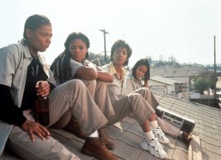 Queen Latifah, Kimberly Elise, Vivica Fox and Jada Pinkett all sitting on the roof of a house in a scene from the film 'Set It Off', 1996