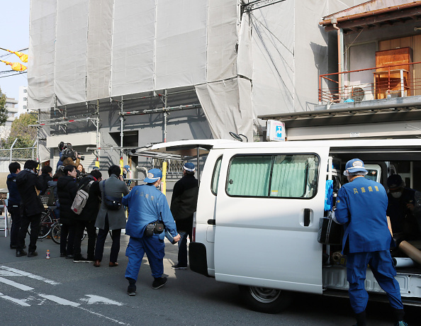 Hyogo prefectural police (R) are pictured at the scene as they investigate an apartment (L) where a decapitated head was found in Osaka on February 25, 2018. Japanese police are questioning a US man in custody after a decapitated head was found in an Osaka apartment he was renting, local media reported on February 25.