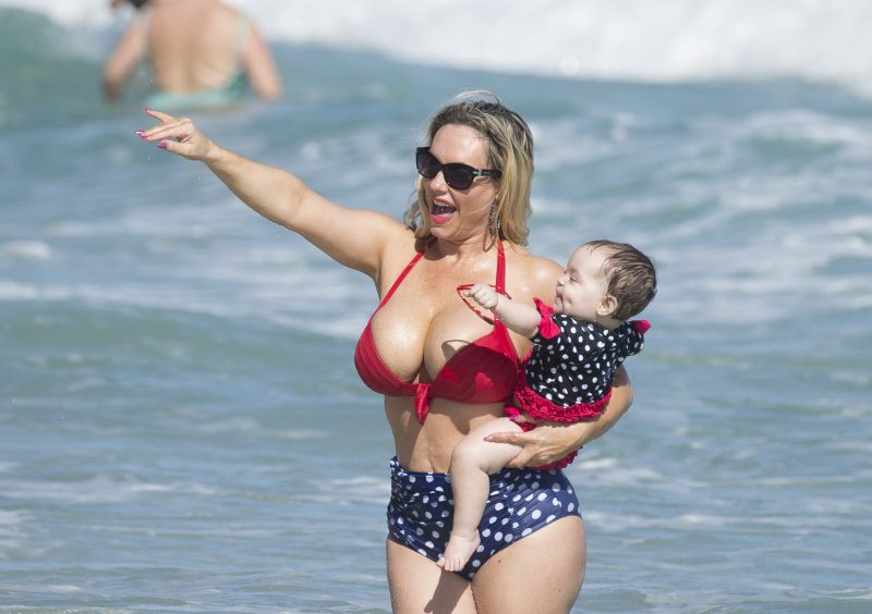 Coco Austin shows off her bikini body on the beach in Miami while playing with baby Chanel on vacation with husband Ice T.