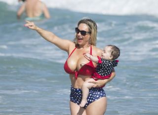 Coco Austin shows off her bikini body on the beach in Miami while playing with baby Chanel on vacation with husband Ice T.