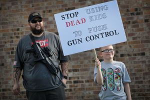 KILLEEN, TX - MARCH 24: James Everard and his son Steven, 9, join a group advocating for the rights of gun owners, as they stage a counter-protest near a March for Our Lives rally on March 24, 2018 in Killeen, Texas. More than 800 March for Our Lives events, organized by survivors of the Parkland, Florida school shooting on February 14 that left 17 dead, are taking place around the world to call for legislative action to address school safety and gun violence.