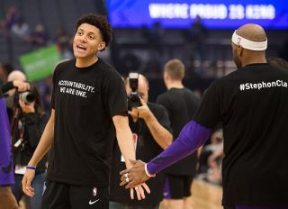 Sacramento Kings forward Justin Jackson (25) slaps hands with Sacramento Kings guard Vince Carter (15) as they wear T-shirts bearing the name of Stephon Clark during a game at Golden 1 Center on Sunday March 25, 2018 in Sacramento, Calif. The Kings and Celtics wore shirts bearing the name of the unarmed man, Stephon Clark, who was killed by Sacramento police. The black warm-up shirts have "Accountability. We are One" on the front and "Stephon Clark" on the back.