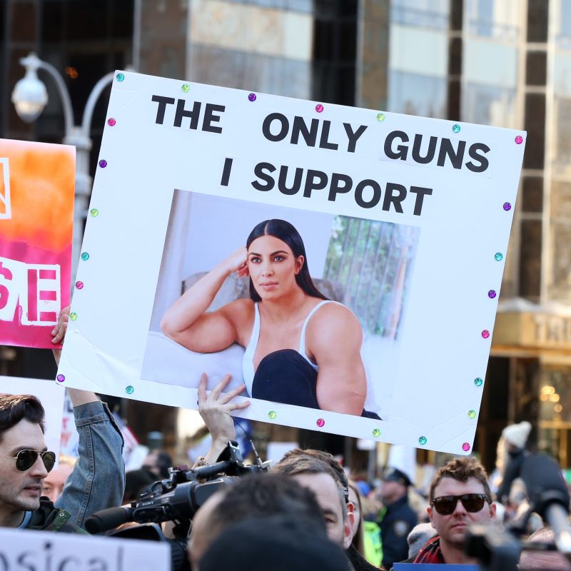Demonstrators, holding a variety of signs, protest at the 'March for our Lives' gathering in New York City, New York on March 24, 2018. Demonstrators include Fathers and daughters, mothers and daughters and groups of women. One humorous sign shows a photo of Kim Kardashion with enormous upper arms and the caption 'The only guns I support.'