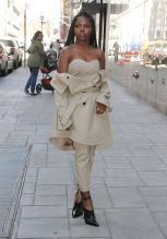Actress and singer Ryan Destiny, star of FOX TV's 'Star', spotted leaving 'Good Day New York' wearing a khaki bustier top with pants that lace up in the rear leg, black mules with ankle ties, and a trench coat draped off the shoulder