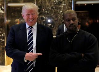 U.S. President-elect Donald Trump and musician Kanye West walk through the lobby at Trump Tower in Manhattan, New York City, U.S., December 13, 2016.