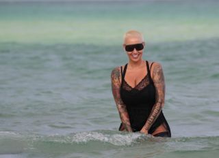 Amber Rose takes a dip in the ocean wearing black lace lingerie in Miami Beach, FL. Amber was relaxing at The Setai hotel with friends and went to cool off in the ocean.