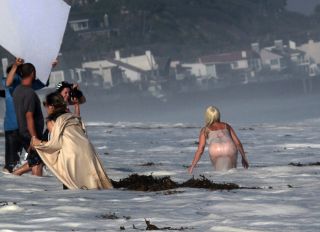 Lady Gaga topless wearing a bikini and thong lingerie for a photoshoot on the beach in Malibu California. The wet and wild photographers and crew got soaked by the big waves.