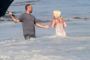 Lady Gaga topless wearing a bikini and thong lingerie for a photoshoot on the beach in Malibu California. The wet and wild photographers and crew got soaked by the big waves.