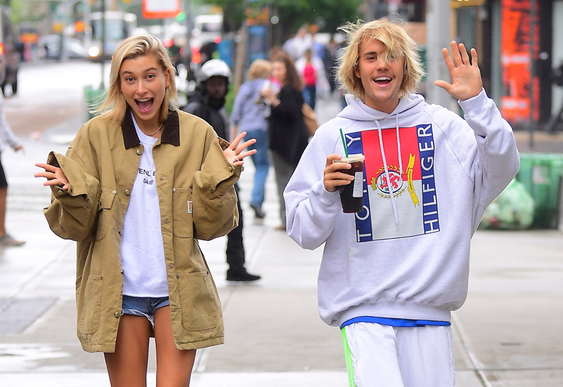 Justin Bieber and Hailey Baldwin looked like the happiest of couples as they stepped out in NYC on Wednesday morning. They spent the night together at Bieber's hotel , and emerged just before Noon . They went to Starbucks together, and happily waved to the paparazzi. Hailey did however hide her engagement ring finger under her jacket sleeves, after flaunting a ring the night before .