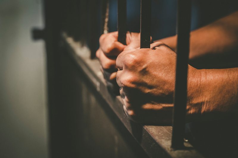 Man Holding Prison Bars