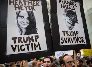 Protesters carry posters of Heather Heyer and Deandre Harris during an anti-President Donald Trump demonstration outside of Trump Tower August 14, 2017 in New York City. Harris was seriously beaten by right-wing extremists, also in Charlottesville, Virginia.