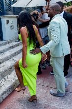 Kim Kardashian neon Versace gown Miami's Versace Mansion for rapper 2Chainz Wedding on Saturday (aug 18). Kanye West sage Louis Vuitton suit and sandals