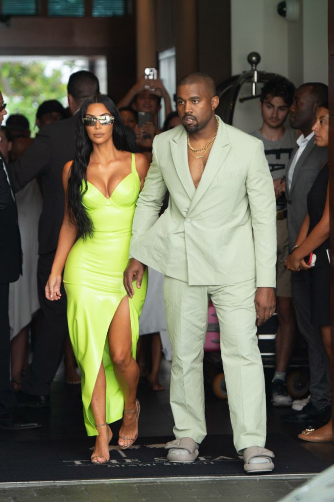 Kim Kardashian neon Versace gown Miami's Versace Mansion for rapper 2Chainz Wedding on Saturday (aug 18). Kanye West sage Louis Vuitton suit and sandals