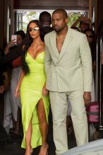 Kim Kardashian neon Versace gown Miami's Versace Mansion for rapper 2Chainz Wedding on Saturday (aug 18). Kanye West sage Louis Vuitton suit and sandals