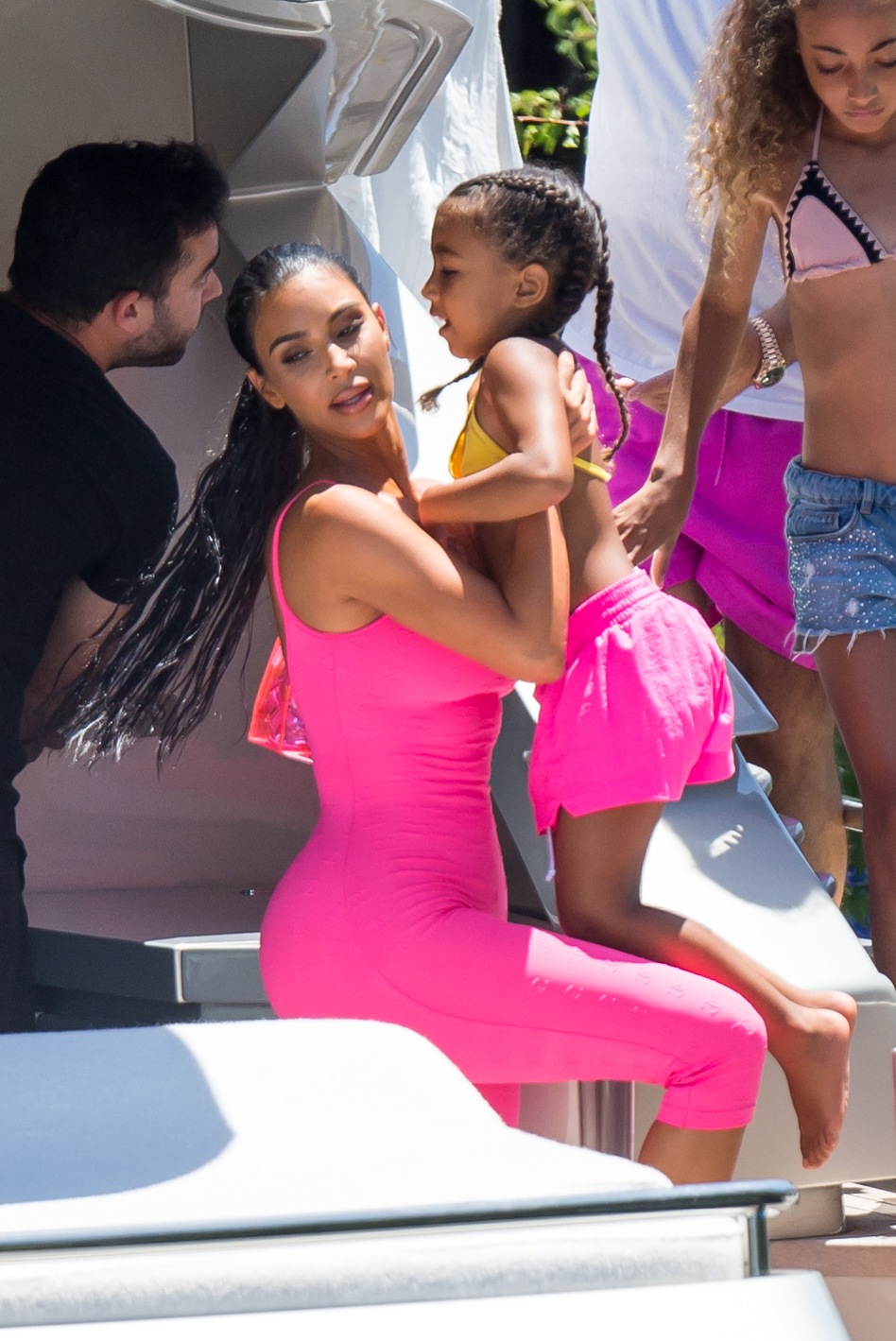 Kim Kardashian curves vintage hot pink Chanel onesie Miami boat trip. cute kids North and Saint, OG crew Jonathan Cheban and Larsa Pippen. Dave Grutman's 'Groot boat Larsa's  daughter Sophia Pippen, ABC's Dancing With The Stars: Juniors.