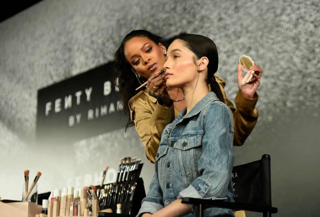 DUBAI, UNITED ARAB EMIRATES - SEPTEMBER 29: Rihanna applies make up on a model during her Fenty Beauty talk in collaboration with Sephora, for the launch of her new Stunna Lip paint "Uninvited" on September 29, 2018 in Dubai, United Arab Emirates.