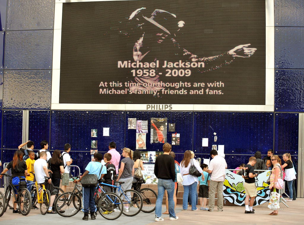 A group of Michael Jackson fans stand at a shrine to the American singer, who died in Los Angeles on Thursday, outside the O2 Arena, London.