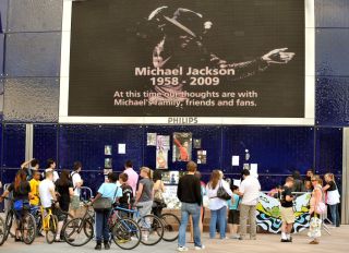 A group of Michael Jackson fans stand at a shrine to the American singer, who died in Los Angeles on Thursday, outside the O2 Arena, London.